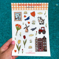 Stickervel in A5 formaat met Hollandse tekeningen, zoals grachtenpanden, kaas, klompen, tulpen, een molen en bloemen