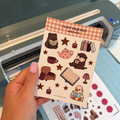 Stickervel in A6-formaat met allemaal leuke dieren en cozy dingen zoals thee, sterren, kaarsjes en meer.