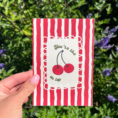 Kaart A6 formaat op linnen look papier met rood gestreepte achtergrond en kersjes met de tekst 'You're the cherry on top'.